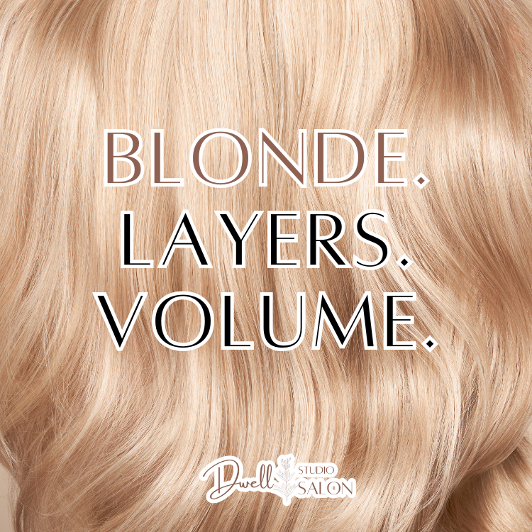 Close-up of warm, voluminous blonde wavy hair with text reading "Blonde. Layers. Volume." at Dwell Studio Salon.