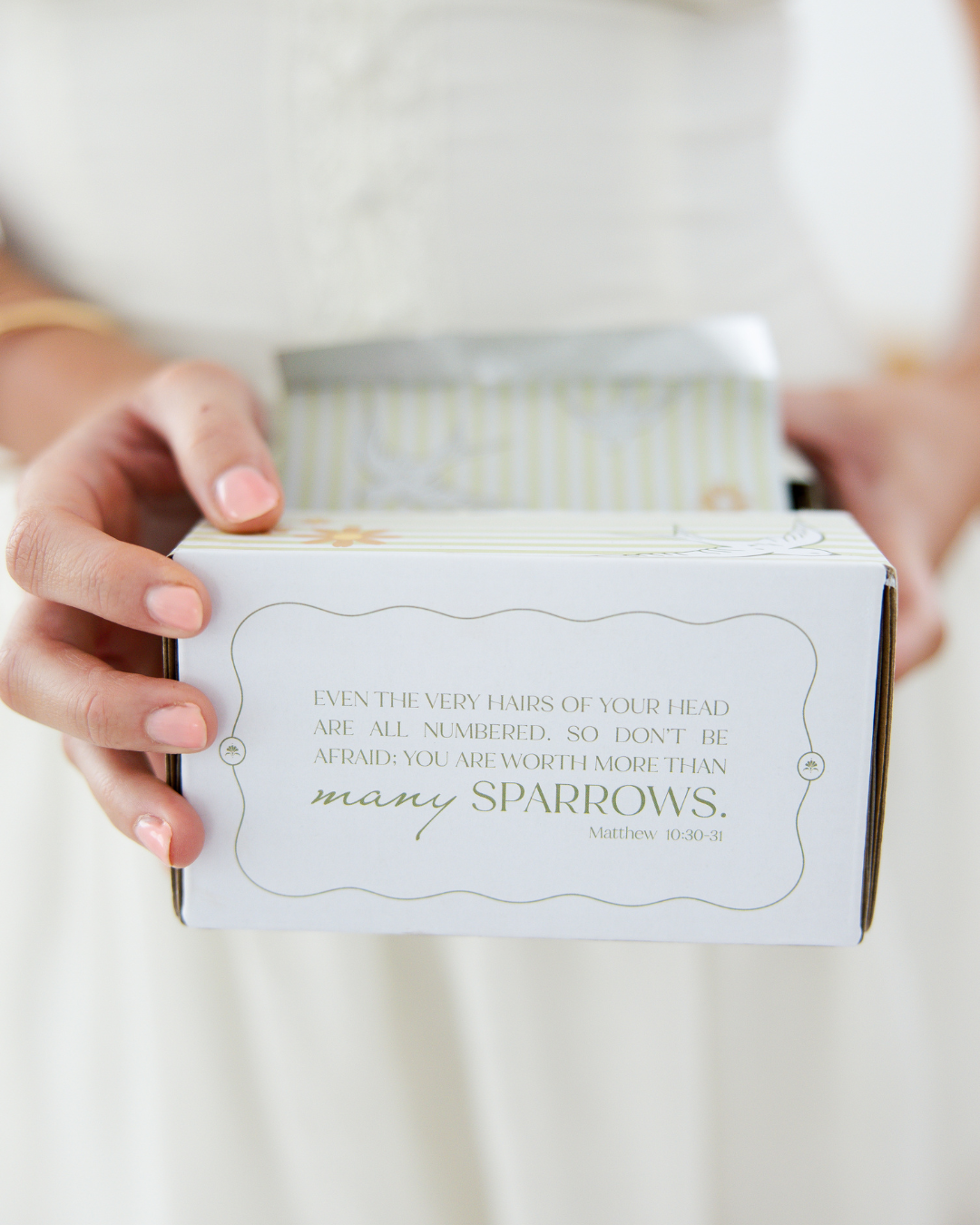 Hands holding a product box featuring a Bible verse, highlighting a faith-driven hair salon in Fort Worth, Texas.