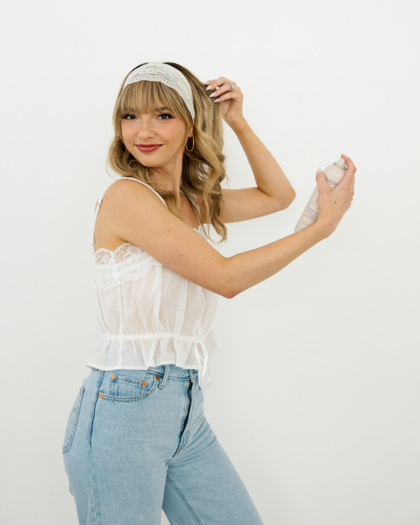 Layered haircut specialist holding hairspray in Fort Worth, Texas.