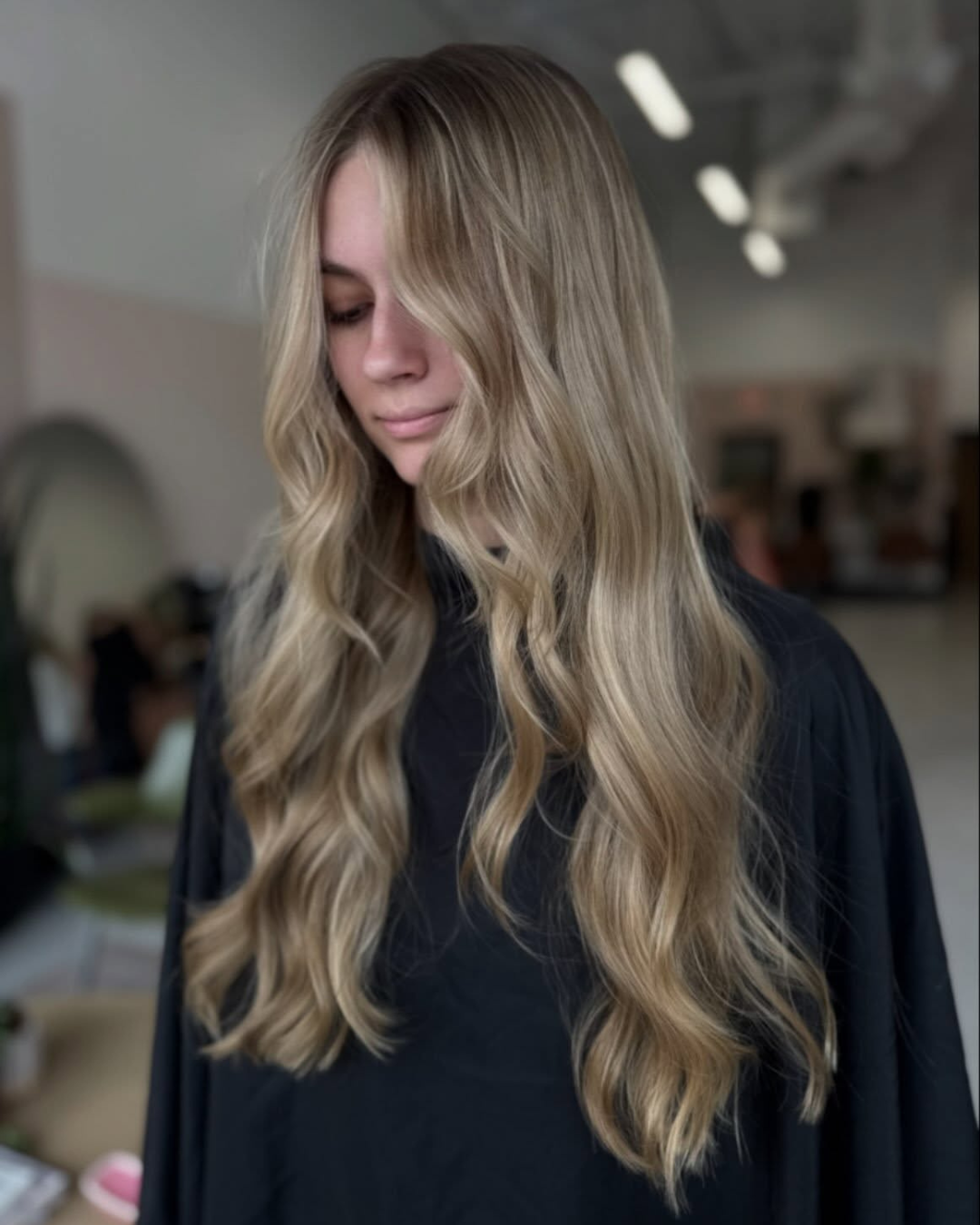 Front view of long lived-in blonde hair with soft waves and face-framing layers.