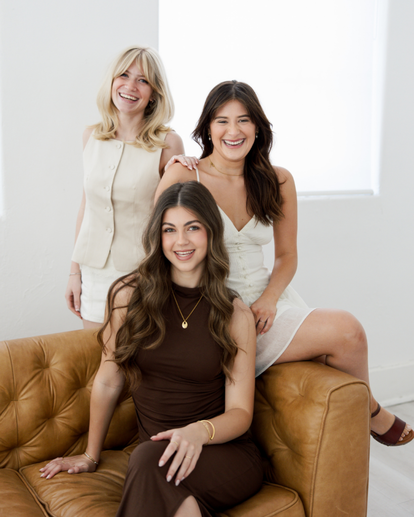 Group portrait of top hairstylists in Fort Worth, Texas, posing together on a couch.